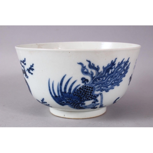 134 - A CHINESE BLUE AND WHITE PORCELAIN BOWL, painted with phoenix and dragons, the base with Kangxi mark... 