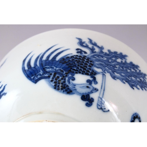 134 - A CHINESE BLUE AND WHITE PORCELAIN BOWL, painted with phoenix and dragons, the base with Kangxi mark... 