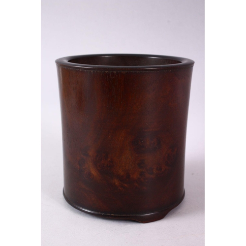 143 - A CHINESE BURR WOOD BRUSH POT, of plain design, on three bracket feet, 16cm high.