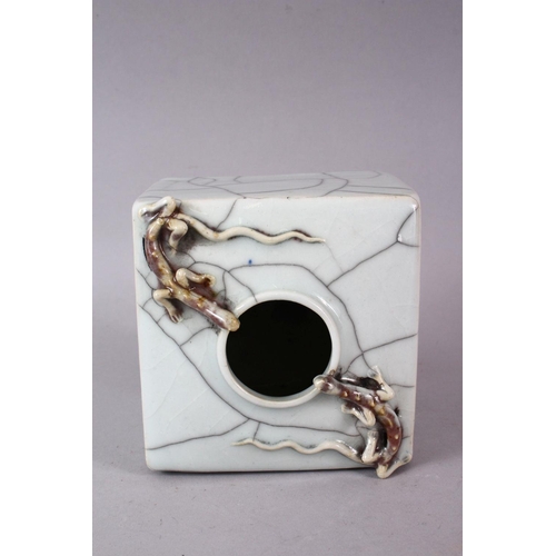 145 - A CHINESE CRACKLE GLAZE SQUARE FORM BRUSH POT, with moulded with chilong, 12cm wide.