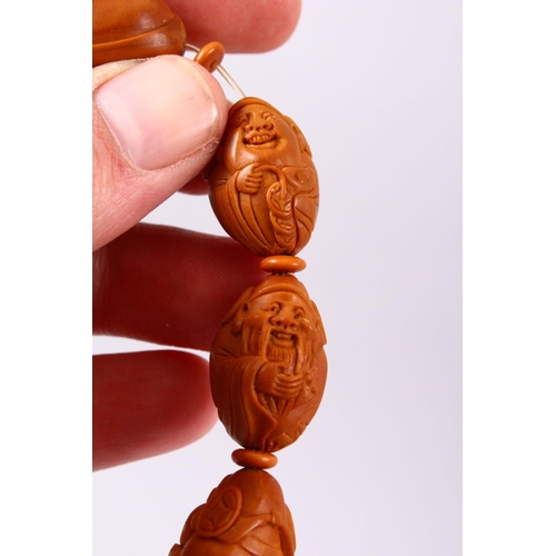 150 - A CHINESE CARVED NUT BRACELET.