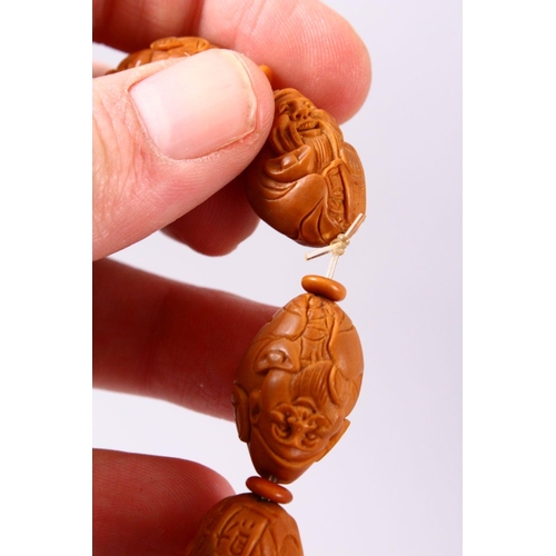 150 - A CHINESE CARVED NUT BRACELET.