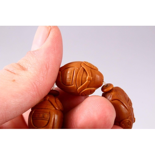 150 - A CHINESE CARVED NUT BRACELET.