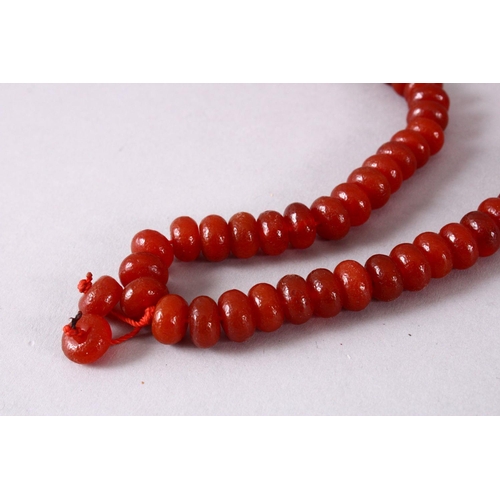 151 - A CHINESE AGATE BEAD NECKLACE, the bead approx 8mm diameter.