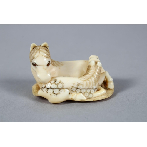 157 - A GOOD JAPANESE MEIJI PERIOD CARVED IVORY NETSUKE OF A RECUMBENT HORSE, to horses in a recumbent pos... 