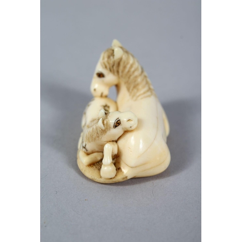 157 - A GOOD JAPANESE MEIJI PERIOD CARVED IVORY NETSUKE OF A RECUMBENT HORSE, to horses in a recumbent pos... 