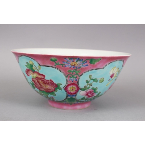 206 - A CHINESE PINK GROUND FAMILLE ROSE PORCELAIN BOWL, with panels of native flora on a blue ground, the... 