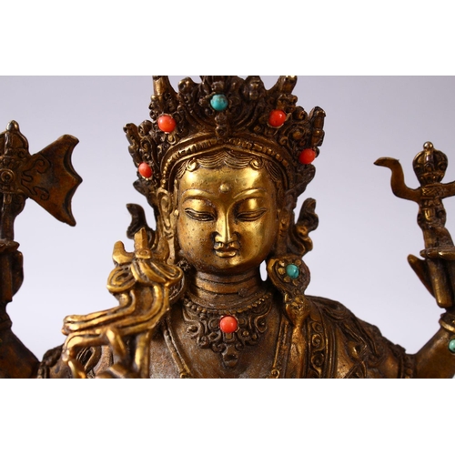 236 - A GOOD TIBETAN GILT BRONZE FIGURE OF A MULTI ARMED DIETY, inlaid with semi precious stones, 22.5cm h... 