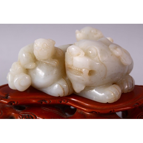 244 - A GOOD CHINESE CARVED WHITE JADE FIGURE OF THREE LION & BOXWOOD STAND, one larger dog with two young... 