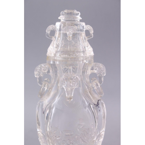 266 - AN 18TH CENTURY CHINESE CARVED ROCK CRYSTAL VASE AND COVER, with rams head and ring handles, with fl... 