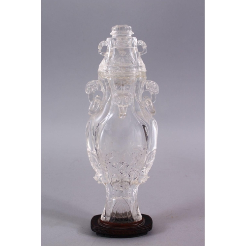 266 - AN 18TH CENTURY CHINESE CARVED ROCK CRYSTAL VASE AND COVER, with rams head and ring handles, with fl... 