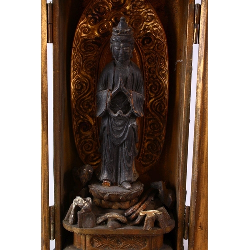 282 - A 19TH CENTURY JAPANESE CARVED WOODEN ENCLOSED FIGURE OF KWANNON / DIETY, housed within a wooden twi... 