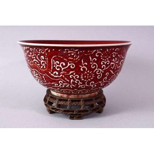 306 - A CHINESE COPPER RED CARVED COPPER RED PORCELAIN DRAGON BOWL, with decoration of dragins amongst flo... 