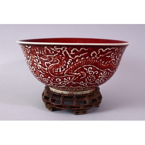 306 - A CHINESE COPPER RED CARVED COPPER RED PORCELAIN DRAGON BOWL, with decoration of dragins amongst flo... 