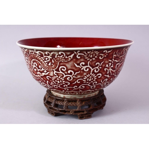 306 - A CHINESE COPPER RED CARVED COPPER RED PORCELAIN DRAGON BOWL, with decoration of dragins amongst flo... 