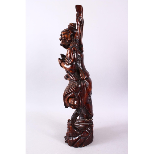 313 - A LARGE 19TH CENTURY CHINESE CARVED HARDWOOD FIGURE OF A DEVIL, stood upon a wave formed base with i... 