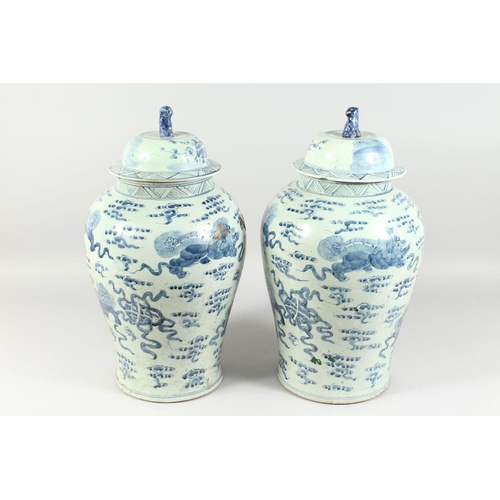 341 - A PAIR OF 20TH CENTURY CHINESE BLUE AND WHITE BALUSTER SHAPE TEMPLE JARS AND COVERS, painted with li... 