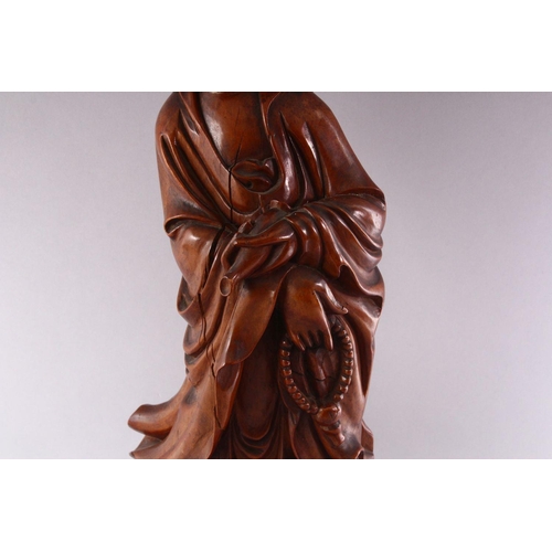 349 - A GOOD LARGE CHINESE CARVED WOOD FIGURE OF GUANYIN, standing on a dragon, 55cm high.