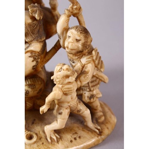 35 - A JAPANESE MEIJI PERIOD CARVED IVORY OKIMONO GROUP - depicting figures attacking oni demons, one dog... 