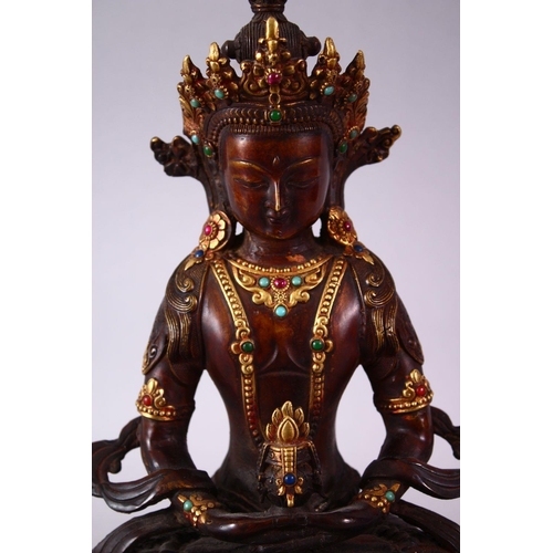 49 - A CHINESE GILT BRONZE INLAID FIGURE OF A DEITY / BUDDHA, in a seated position with an object in hand... 