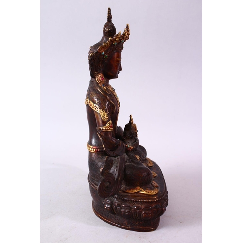 49 - A CHINESE GILT BRONZE INLAID FIGURE OF A DEITY / BUDDHA, in a seated position with an object in hand... 