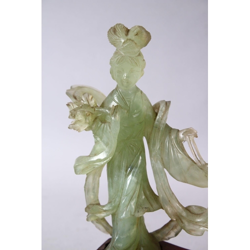 50 - A 19TH / 20TH CENTURY CHINESE CARVED JADE FIGURE OF GUANYIN, upon a carved wooden base, 16cm x 11cm