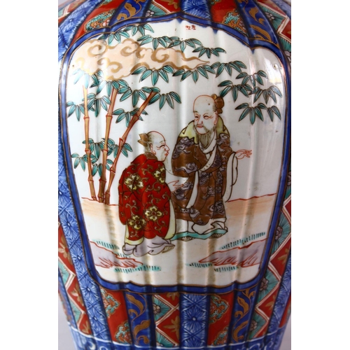 6 - A LARGE IMARI VASE AND COVER, the ribbed body painted with panels of flowers and figures, the cover ... 