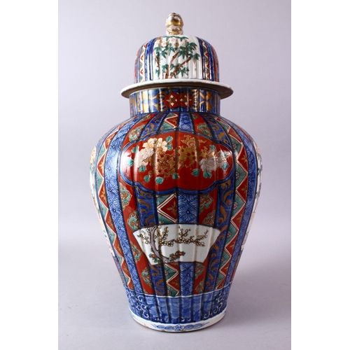 6 - A LARGE IMARI VASE AND COVER, the ribbed body painted with panels of flowers and figures, the cover ... 