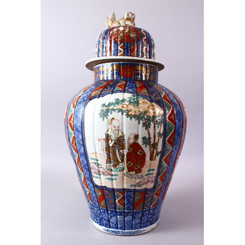 6 - A LARGE IMARI VASE AND COVER, the ribbed body painted with panels of flowers and figures, the cover ... 