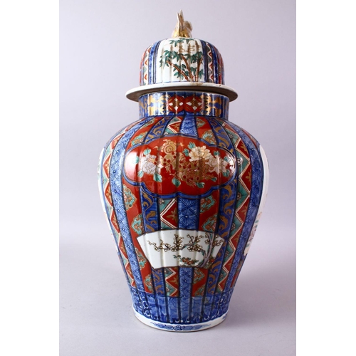 6 - A LARGE IMARI VASE AND COVER, the ribbed body painted with panels of flowers and figures, the cover ... 