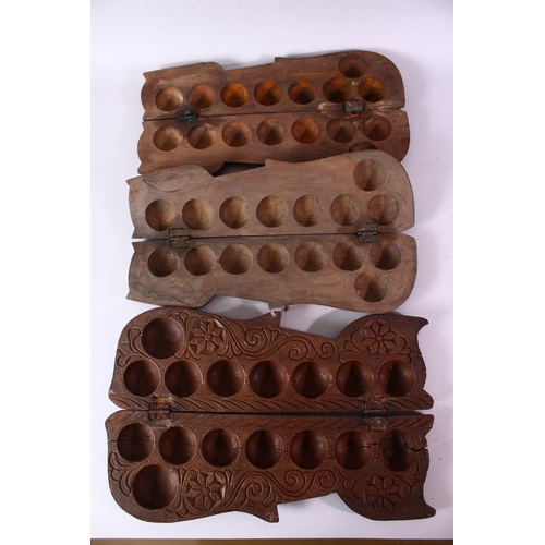 617 - THREE INDIAN CARVED WOODEN SPICE BOXES, largest 40cm long.