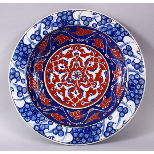 746 - A RARE IZNIK POTTERY PLATE, decorated with blue, white and red decoration depicting stylized floral ... 