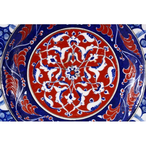 746 - A RARE IZNIK POTTERY PLATE, decorated with blue, white and red decoration depicting stylized floral ... 