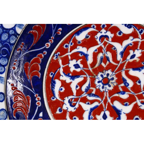 746 - A RARE IZNIK POTTERY PLATE, decorated with blue, white and red decoration depicting stylized floral ... 