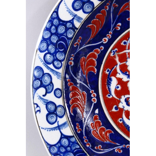 746 - A RARE IZNIK POTTERY PLATE, decorated with blue, white and red decoration depicting stylized floral ... 