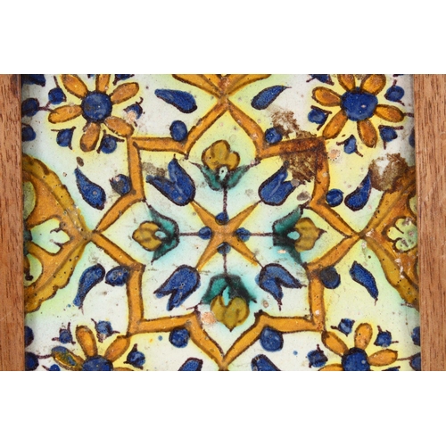 754 - A 19TH / 20TH CENTURY TURKISH POTTERY TILE SECTION, housed within a wooden frame with feet, decorate... 