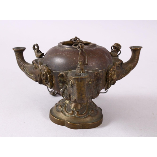 768 - AN INDIAN ELEPHANT FORMED BRONZE HANGING OIL LAMP, with three elephant heads and chains, 16cm wide.