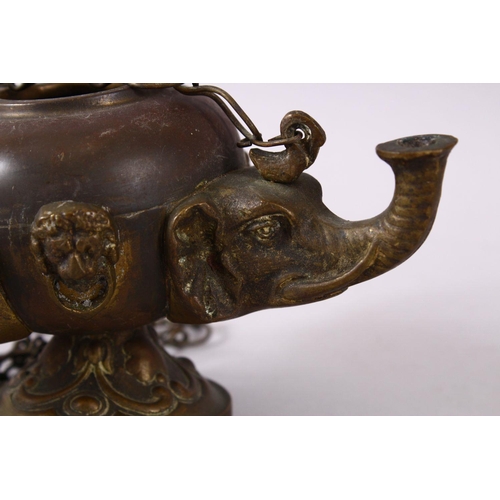 768 - AN INDIAN ELEPHANT FORMED BRONZE HANGING OIL LAMP, with three elephant heads and chains, 16cm wide.