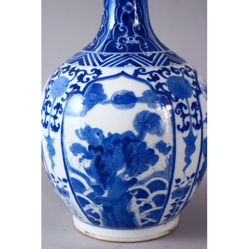 77 - A CHINESE KANGXI STYLE BLUE & WHITE PORCELAIN BOTTLE VASE, with panel decoration of lion dogs and fl... 