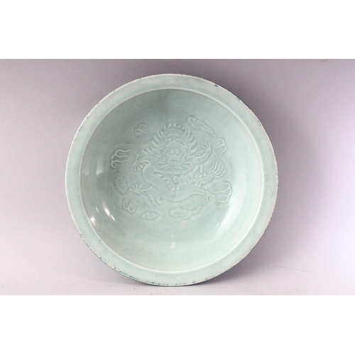 85 - A 20TH CENTURY CHINESE CELEDON CIRCULAR DISH, the centre with moulded dragon decoration, green groun... 