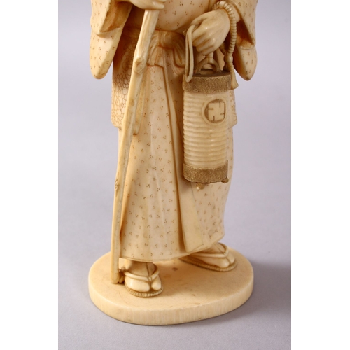 164E - A JAPANESE MEIJI PERIOD CARVED IVORY OKIMONO - MAN, stood in traditional dress, holding his staff an... 