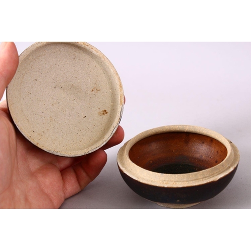 106 - A SMALL CHINESE TREACLE GLAZED CIRCULAR POTTERY BOX AND COVER, the cover with moulded dragon decorat... 
