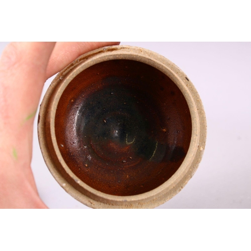 106 - A SMALL CHINESE TREACLE GLAZED CIRCULAR POTTERY BOX AND COVER, the cover with moulded dragon decorat... 