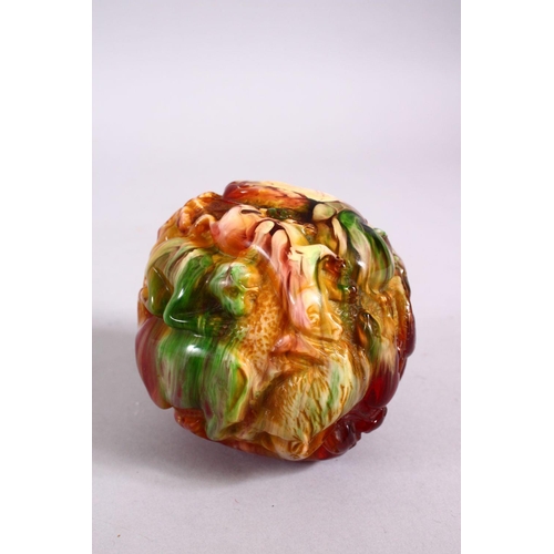 94 - A CHINESE CARVED BAKELITE OR CHERRY AMBER ZODIAC BALL, carved with animals, 9cm diameter.