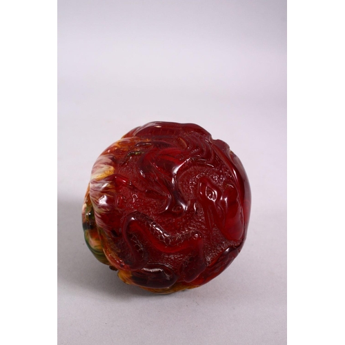 94 - A CHINESE CARVED BAKELITE OR CHERRY AMBER ZODIAC BALL, carved with animals, 9cm diameter.