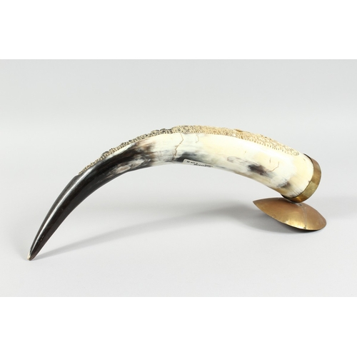 12 - A BOVINE HORN carved with elephants, 18 in. long.