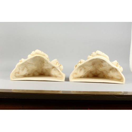 19 - A PAIR OF COMPOSITION WALL POCKETS with mask and scrolls, 1 ft. 2 in. wide.