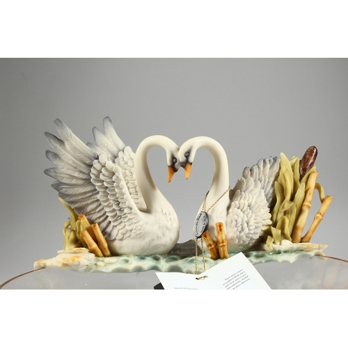 21 - A GLASS CIRCULAR CENTREPIECE with two porcelain swans, 1 ft. 2 in.