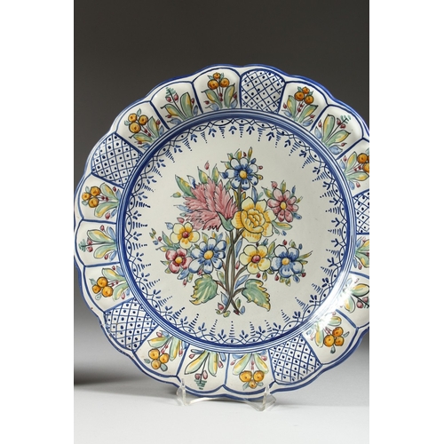 23 - TWO POTTERY DISHES painted with flowers, 13 in. diameter.