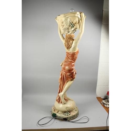 57 - A COMPOSITION CREAM AND GILDED UPLIGHTER formed as a classical female figure holding a basket, 4 ft.... 